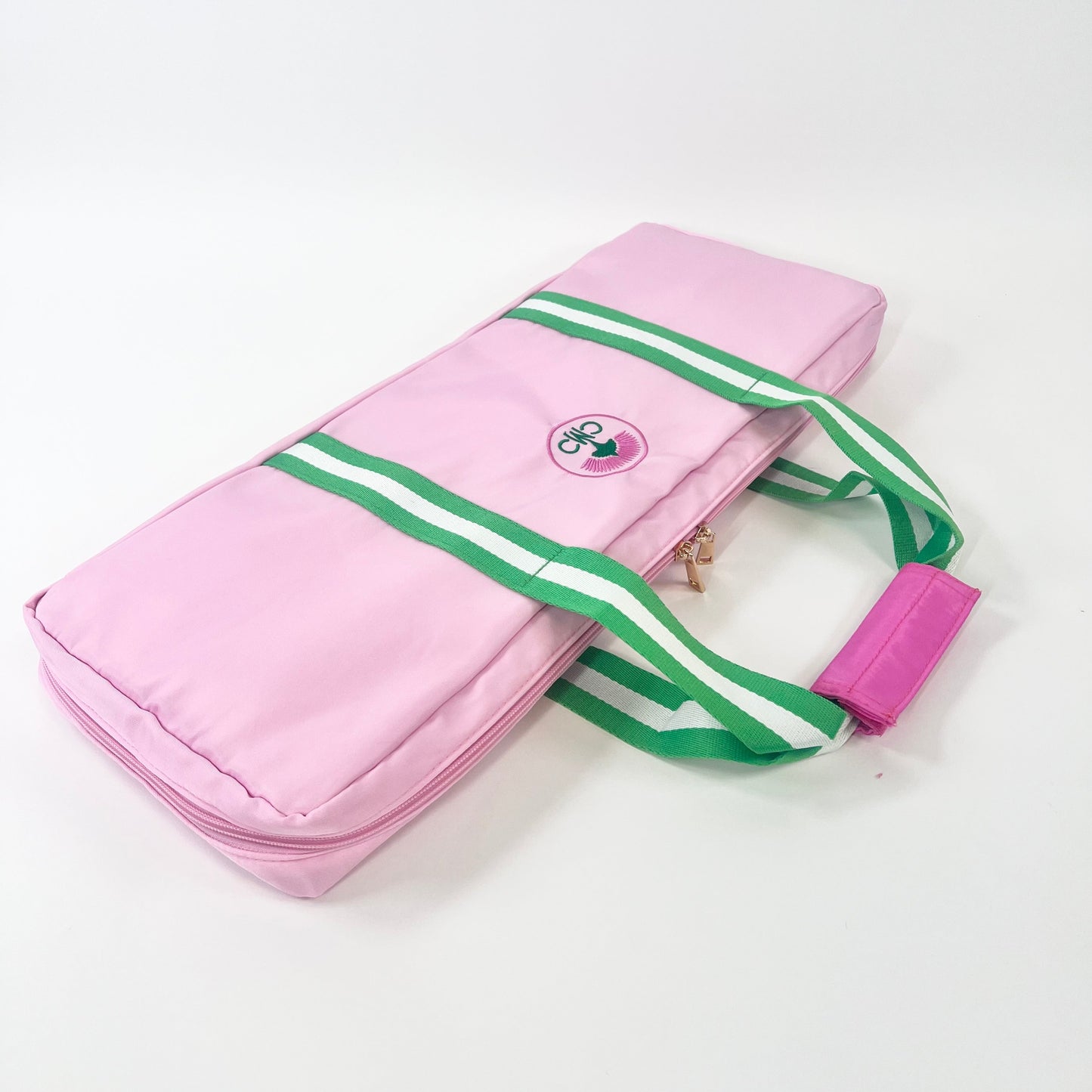 Pink rack bag with green striped straps on a white background