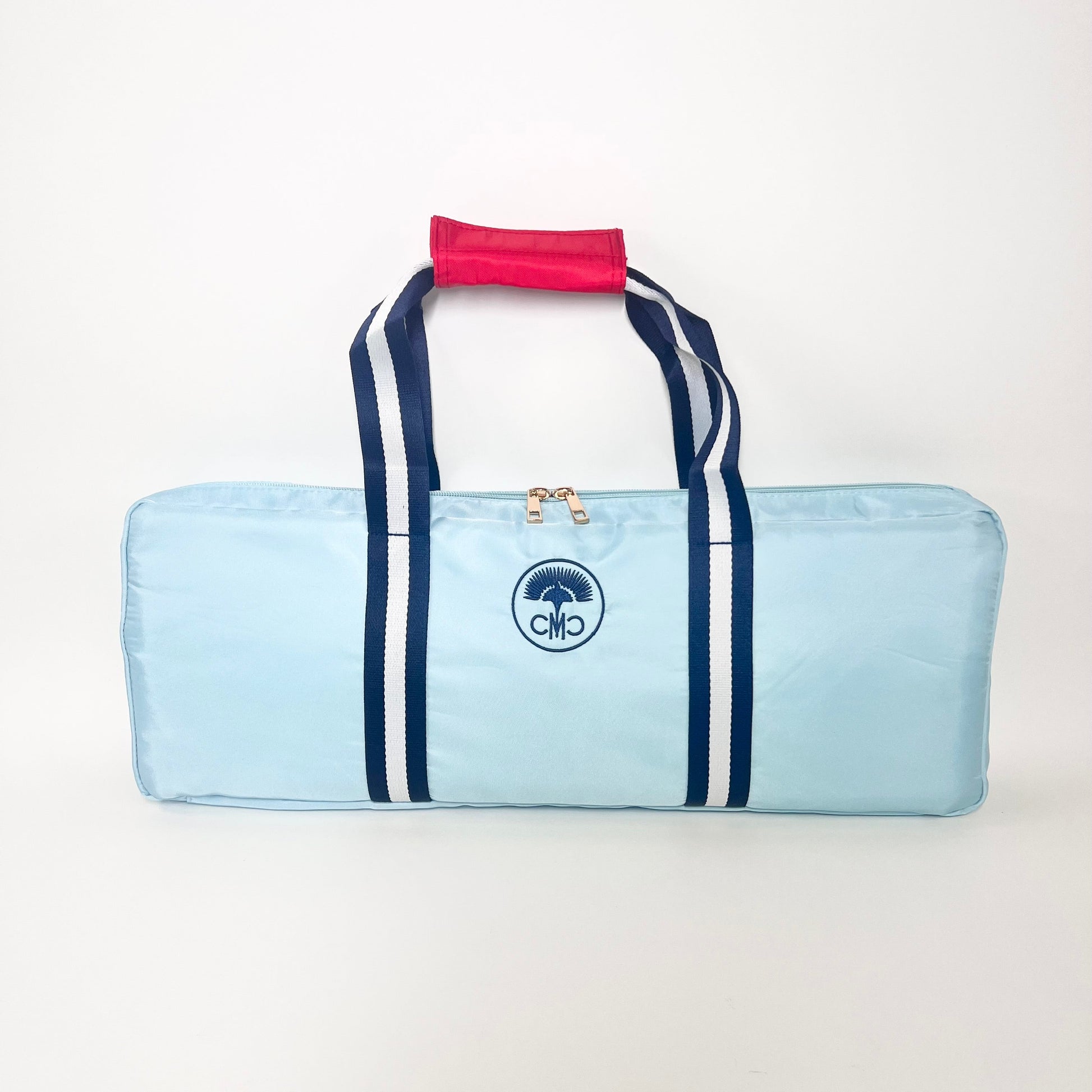 Light blue rack bag with navy stripes and a red handle on a white background