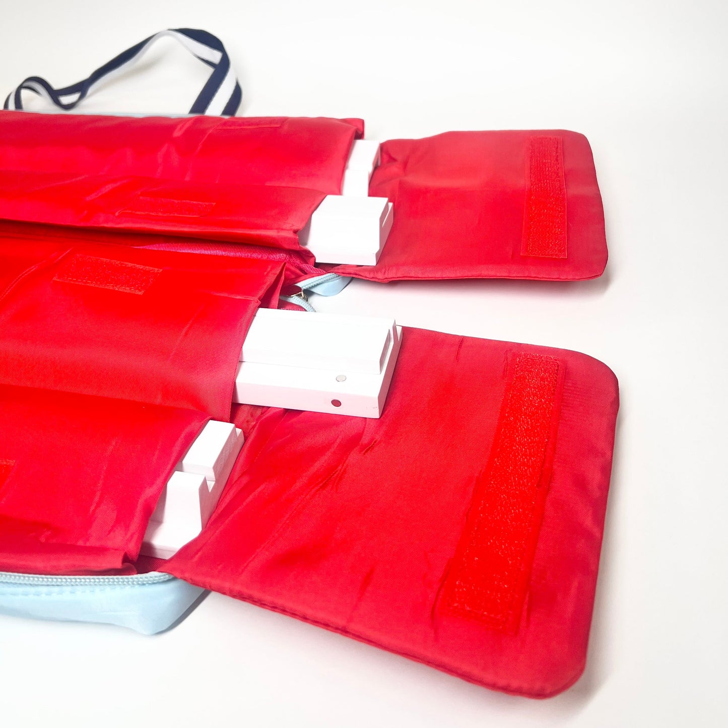 Rack bag with Red interior with navy/white straps on a white background