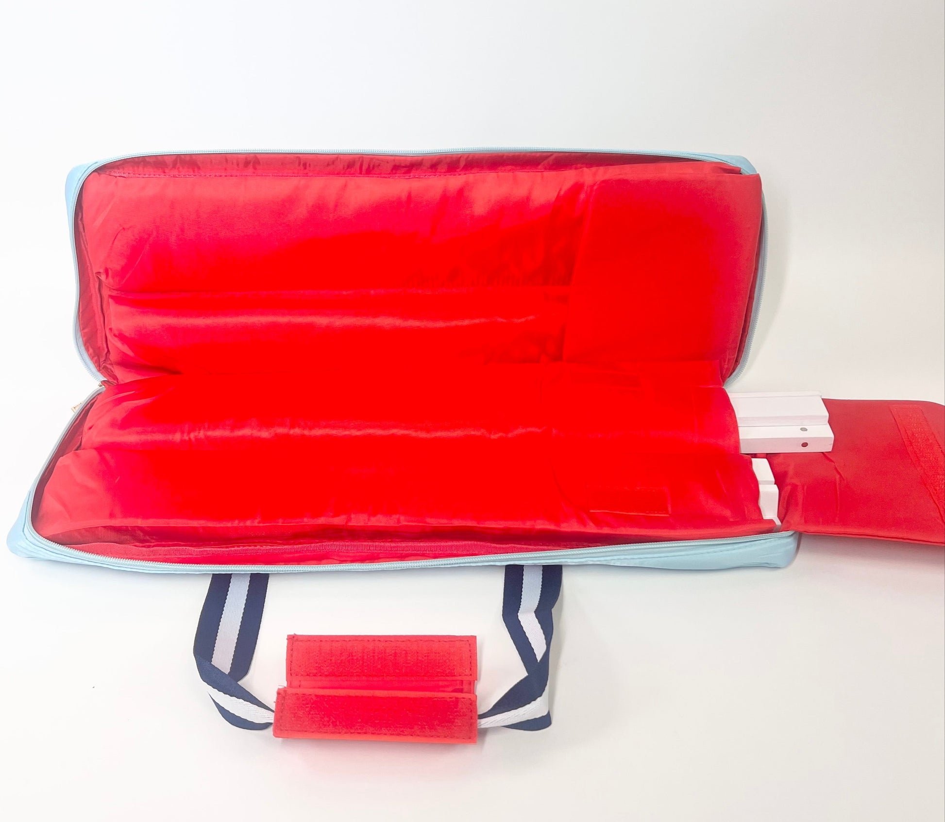 Blue rack bag w/ navy and white striped handle with a red interior on a white background
