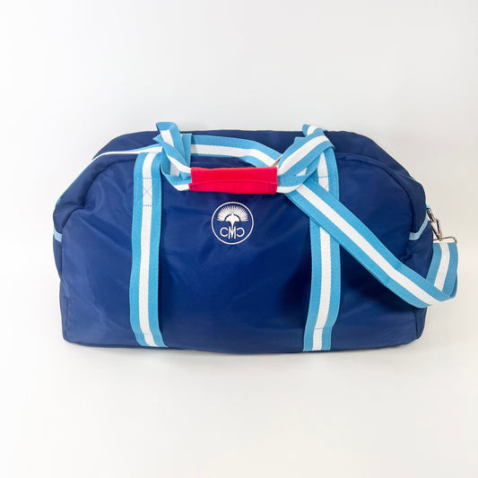 Blue duffel bag with white straps and red accent on a white background
