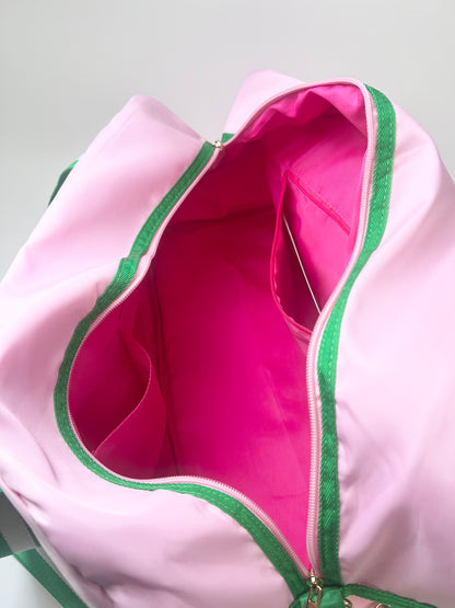 Pink bag with green trim showing hot pink interior with pockets