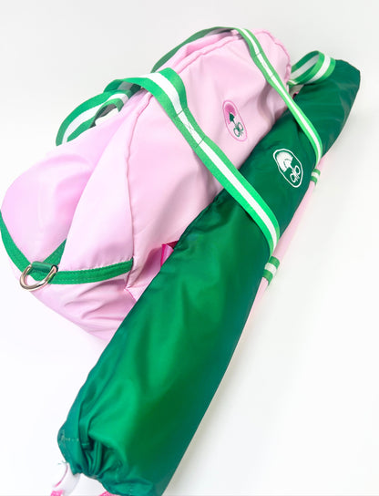 Pink and green duffel with mat bag attached to the front with a logo on a white background